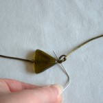 Make a knot as close to the bead as possible using paperclip
