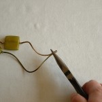 Using pliers, crimp closed